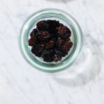 In this photo, you can see an açai bowl ingredients such as dried sour cherries