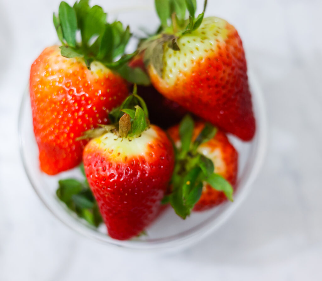 In this photo, you can see an açai bowl ingredients such as strawberries