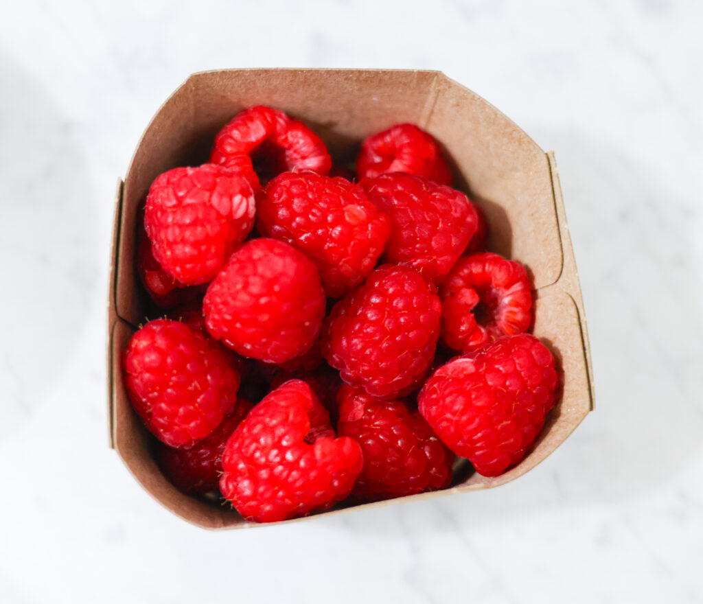 In this photo, you can see an açai bowl ingredients such as raspberries