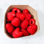 In this photo, you can see an açai bowl ingredients such as raspberries