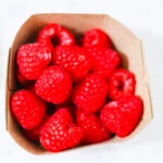 In this photo, you can see an açai bowl ingredients such as raspberries