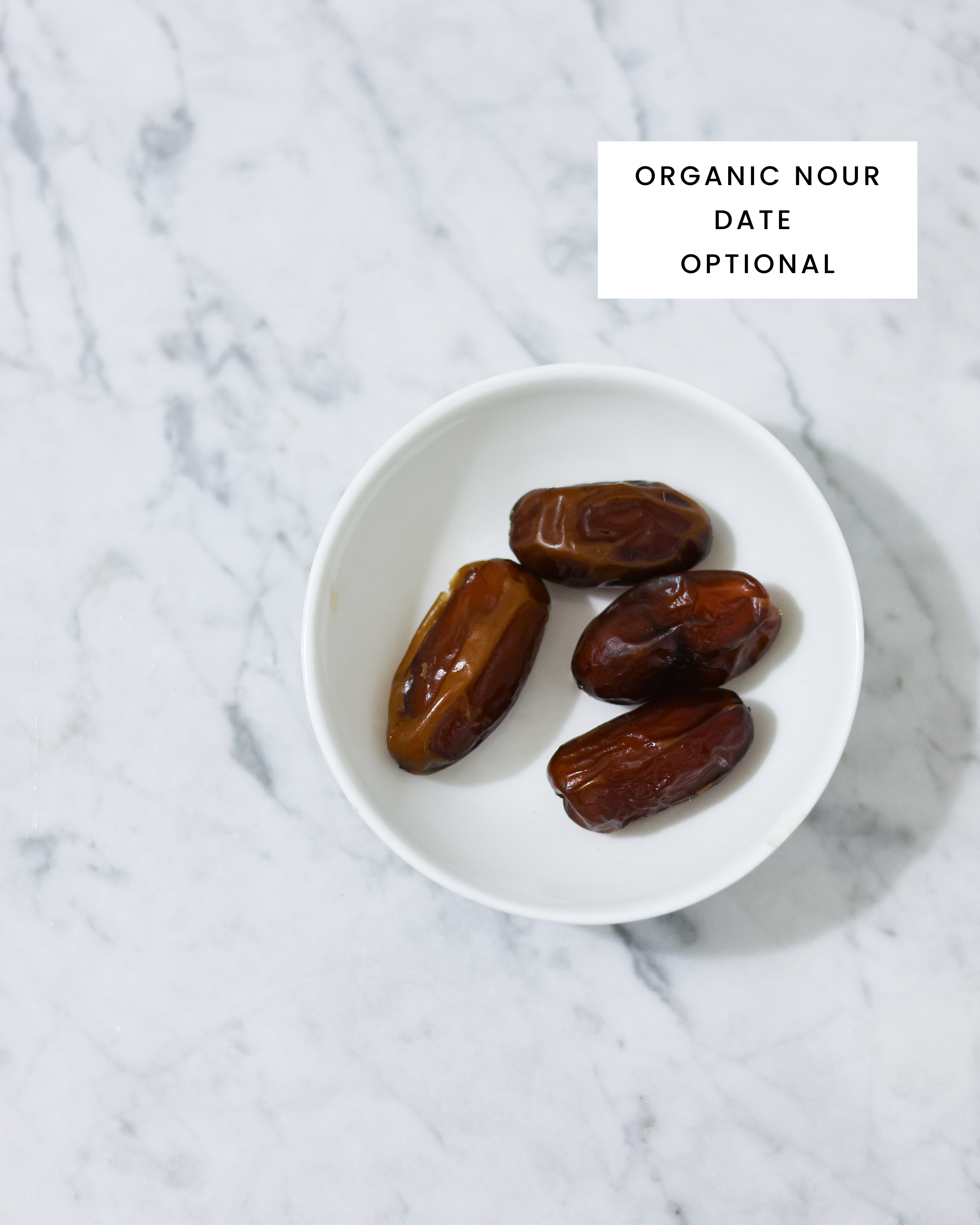 Here you can see organic dates in a white porcelain bowl on Carrara marble
