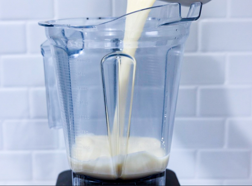 In this picture you can see a vitamix ascent series container filled with oat milk