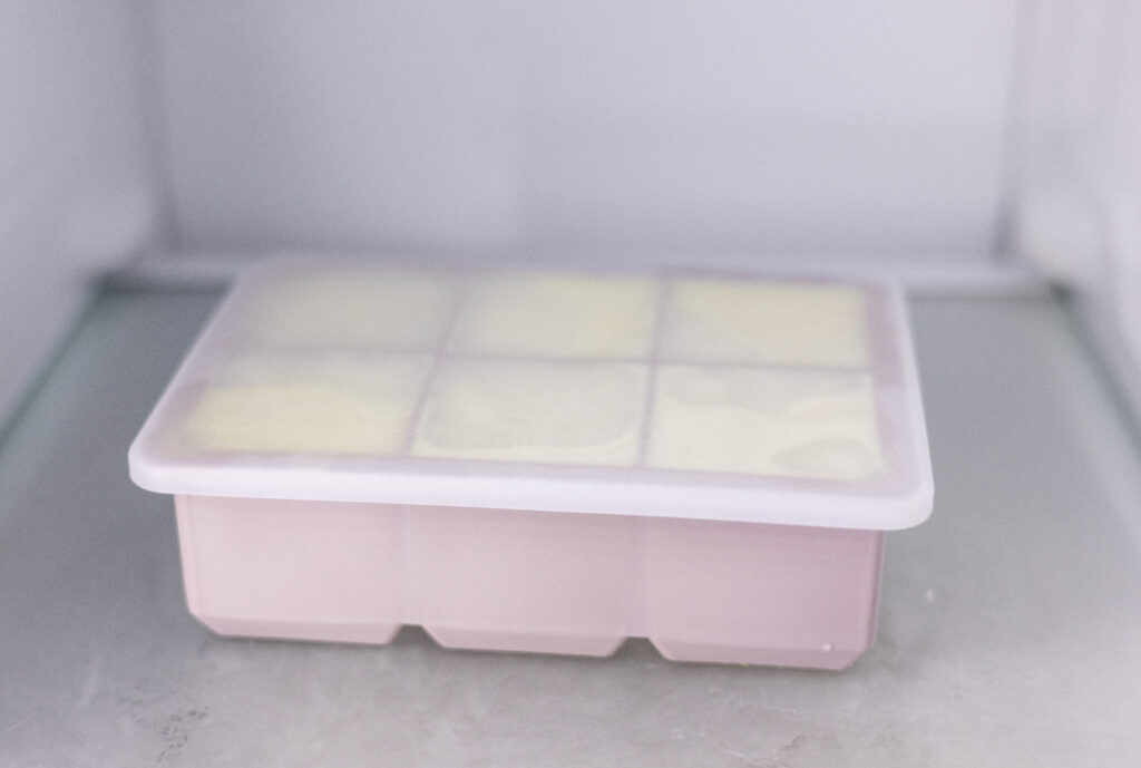 This picture show oat milk in an ice cube tray in a freezer