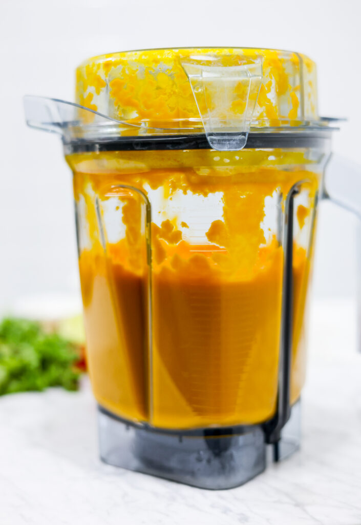 In this photo you can see a vitamix container with a puréed Vitamix Thai Pumpkin Soup in it.