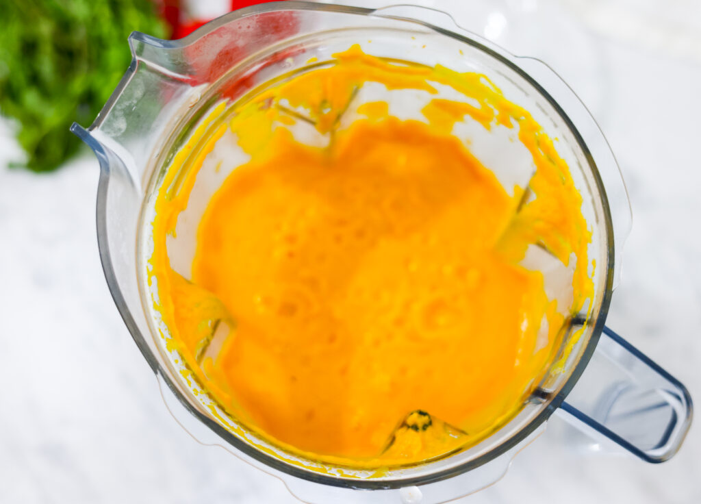 In this photo you can see a vitamix container with a puréed Vitamix Thai Pumpkin Soup in it.