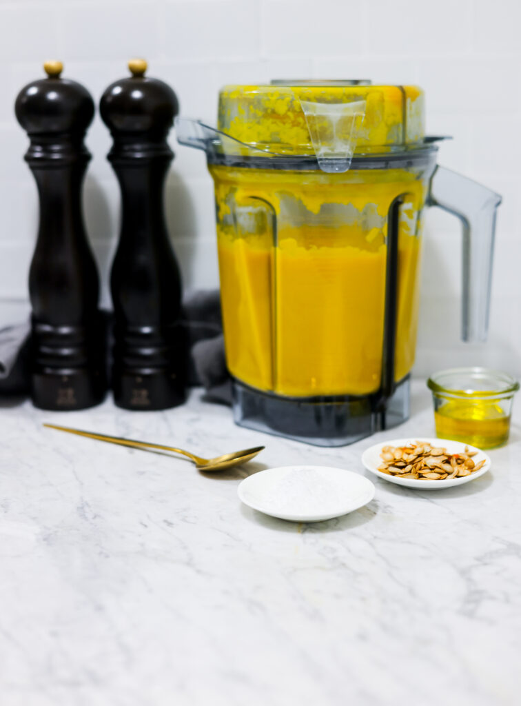 In this photo you can see a vitamix container with a puréed Vitamix Thai Pumpkin Soup in it.