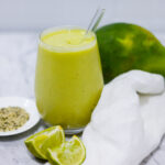 In this picture you can see the mango avocado smoothie. As decoration you can see an organic lime in front of the crystal glass.