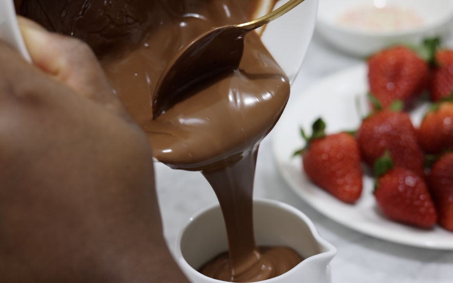 In this picture you can see a fine bone china jar filled with vegan warm chocolate. The 12 red organic strawberries are plated on a fine bone china plate besides the jar. In the back you can see the organic colorful sprinkle garnish.

The whole setting is positioned on a white Carrara marble desk.
