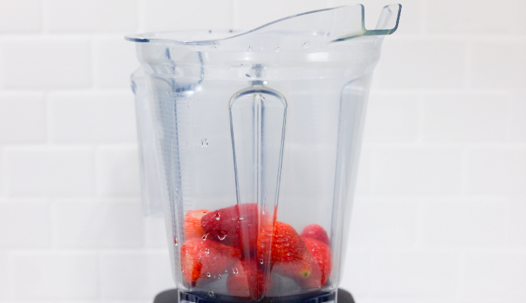 In this picture you can see a Vitamix container filled with organic strawberries which will be puréed