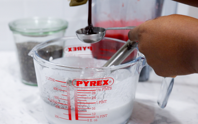 In this picture you can see a Pyrex glass filled with coconut milk and all the ingredients for Strawberry Chia Pudding