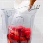 In this picture you can see a Vitamix container filled with organic strawberries which will be puréed