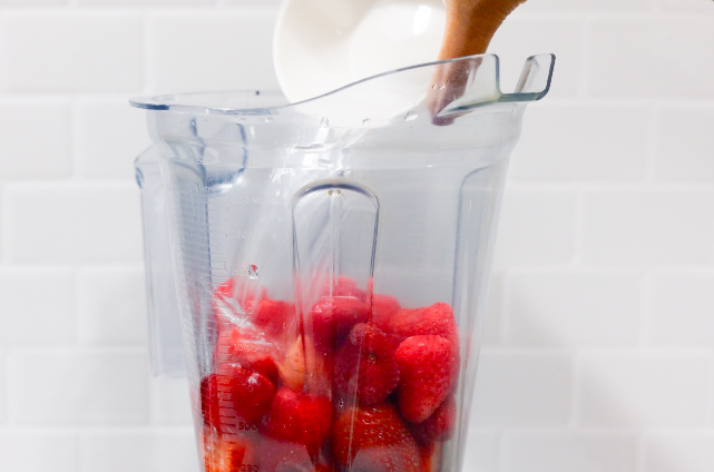 In this picture you can see a Vitamix container filled with organic strawberries which will be puréed