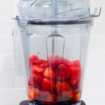 In this picture you can see a Vitamix container filled with organic strawberries which will be puréed