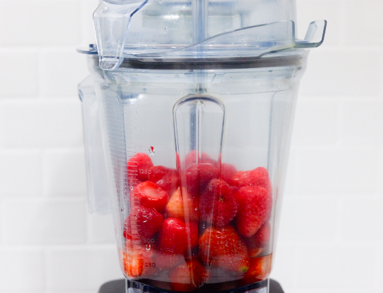 In this picture you can see a Vitamix container filled with organic strawberries which will be puréed