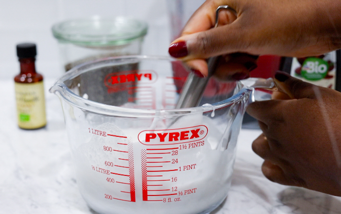 In this picture you can see a Pyrex glass filled with coconut milk and all the ingredients for Strawberry Chia Pudding