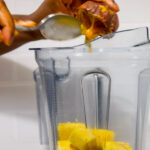 In this picture you can see the passion fruit is being added to the other ingredients in the Vitamix container